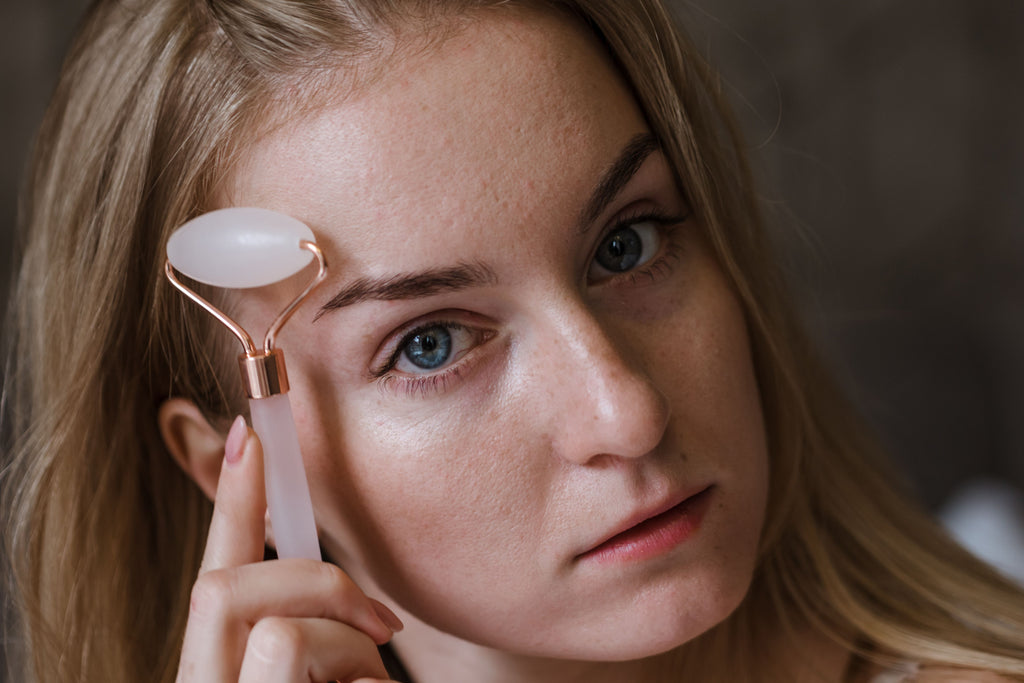 Woman using rose quartz facial roller in her skincare routine